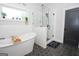 Elegant bathroom with a soaking tub, glass-enclosed shower, and modern black hexagonal tile flooring at 115 W Wind Ct, Tyrone, GA 30290