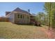 View of the back exterior featuring a deck, yard, and mature trees at 115 W Wind Ct, Tyrone, GA 30290