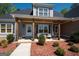 Inviting front porch features wood columns, cozy seating, and a charming welcome mat at 115 W Wind Ct, Tyrone, GA 30290