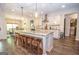 Modern kitchen with a large island, barstool seating, pendant lighting, and stainless steel appliances at 115 W Wind Ct, Tyrone, GA 30290