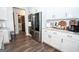 Kitchen features stainless appliances, white cabinets and a view of a half bathroom at 115 W Wind Ct, Tyrone, GA 30290
