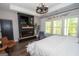 Bright main bedroom featuring a fireplace, mounted TV, and modern furnishings at 115 W Wind Ct, Tyrone, GA 30290
