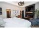 Comfortable main bedroom featuring a fireplace, mounted TV, and modern furnishings at 115 W Wind Ct, Tyrone, GA 30290