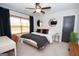 Well-lit main bedroom with a large bed, desk, and stylish decor at 115 W Wind Ct, Tyrone, GA 30290