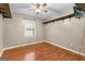 This bedroom features wood floors, a ceiling fan, a window, and painted walls at 324 County Line Rd, Fayetteville, GA 30215