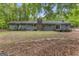Rear exterior view showing the home's facade, multiple windows, and a wooded backyard at 324 County Line Rd, Fayetteville, GA 30215