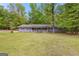 Quaint ranch home with light blue siding, red shutters and a well-manicured lawn surrounded by mature trees at 324 County Line Rd, Fayetteville, GA 30215