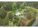 A captivating aerial view of a secluded home nestled among lush greenery with a winding driveway and a private pool at 24 Shiloh Church Rd, Carrollton, GA 30116