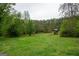 Lush backyard featuring verdant trees, manicured lawn, and a charming playset, perfect for outdoor enjoyment at 24 Shiloh Church Rd, Carrollton, GA 30116