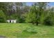 The backyard features a shed, mature trees, and expansive green space at 24 Shiloh Church Rd, Carrollton, GA 30116