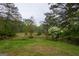 Lush property with a canopy of trees and flowering bushes, perfect for a tranquil retreat at 24 Shiloh Church Rd, Carrollton, GA 30116
