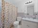 Bathroom with a floral shower curtain, toilet, and vanity at 9155 Lakeview Sw Dr, Covington, GA 30014