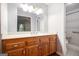 Bright bathroom featuring a wooden vanity, large mirror, and a shower with a built-in seat at 215 North Mourning Dove N Dr, Fayetteville, GA 30215