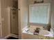 Bathroom featuring a shower stall, soaking tub, and a window with natural light at 220 Camerons Way, Covington, GA 30016