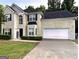 Charming two-story home featuring a well-manicured lawn and attached two car garage at 220 Camerons Way, Covington, GA 30016