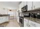 Modern kitchen featuring stainless steel appliances, stone countertops, and white cabinets at 220 Camerons Way, Covington, GA 30016