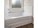 Bright bathroom featuring a white bathtub with subway tile surround and a window for natural light at 1011 Austin Rd, Ellenwood, GA 30294