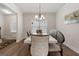 A well-lit dining room with a long marble table and dark wood floors at 1011 Austin Rd, Ellenwood, GA 30294