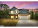 Charming two-story home with a brick facade, gray siding, and a two-car garage under a beautiful violet sky at 1011 Austin Rd, Ellenwood, GA 30294