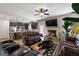 Open-concept living area with leather sofas, a fireplace, a TV, and an adjacent kitchen space at 1011 Austin Rd, Ellenwood, GA 30294