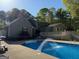 Backyard view featuring a large in-ground pool, deck, patio furniture, and mature trees at 4430 Kings Hwy, Douglasville, GA 30135