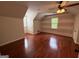 Spacious bedroom featuring hardwood floors, a ceiling fan, and natural light from a window at 4430 Kings Hwy, Douglasville, GA 30135
