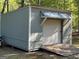 Gray-sided outbuilding with roll-up door, ramp and covered area for storage at 4430 Kings Hwy, Douglasville, GA 30135