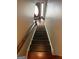 Well-lit stairway with hardwood steps leading to a welcoming foyer featuring a decorative front door at 4430 Kings Hwy, Douglasville, GA 30135