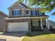Charming two-story home boasts stone accents, gray siding, and a well-maintained front lawn at 1007 Oglethorpe Ct, Woodstock, GA 30188