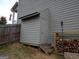 Backyard view of side access door and stacked firewood next to the house at 1007 Oglethorpe Ct, Woodstock, GA 30188