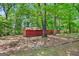 Backyard features a red shed in a wooded lot with mature shade trees at 482 E Lake Rd, Mcdonough, GA 30252