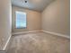 This bedroom is a blank canvas with neutral walls, carpet, and a window at 502 Hinton Farm Way, Dacula, GA 30019