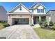Beautiful home exterior with stone accents, manicured lawn, and two car garage at 502 Hinton Farm Way, Dacula, GA 30019