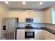 Well-equipped kitchen with stainless steel appliances, granite countertops, and white cabinetry at 502 Hinton Farm Way, Dacula, GA 30019