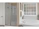 Bright bathroom featuring a soaking tub, glass shower, and natural light from a large window at 225 Suffolk Way, Mcdonough, GA 30252