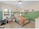 Bedroom featuring a white bed frame with a green accent wall and natural light at 225 Suffolk Way, Mcdonough, GA 30252
