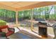 Cozy covered patio with comfortable seating and a grill, overlooking the backyard at 225 Suffolk Way, Mcdonough, GA 30252