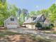 View of craftsman-style home with two-car garage and long drive surrounded by nature at 225 Suffolk Way, Mcdonough, GA 30252