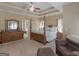 This main bedroom features tray ceilings, neutral walls, a ceiling fan, and a traditional style four-post bed at 225 Suffolk Way, Mcdonough, GA 30252