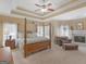 Bedroom with a canopy bed, fireplace, sitting area, and tray ceilings at 225 Suffolk Way, Mcdonough, GA 30252
