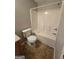 A well-lit bathroom includes a toilet and a bright white shower-tub combination at 403 Buckboard Ln, Locust Grove, GA 30248
