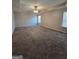Spacious bedroom with plush carpeting, ceiling fan, and natural light from two windows at 403 Buckboard Ln, Locust Grove, GA 30248