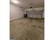 Empty two car garage featuring a metal garage door and concrete flooring at 403 Buckboard Ln, Locust Grove, GA 30248