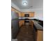 Well-lit kitchen with stainless steel appliances, dark countertops, and wood cabinets at 403 Buckboard Ln, Locust Grove, GA 30248