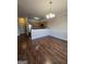 Open concept dining area and kitchen with hardwood floors, stainless steel appliances, and chandelier at 403 Buckboard Ln, Locust Grove, GA 30248