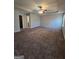 Expansive carpeted main bedroom featuring a ceiling fan and ample natural light at 403 Buckboard Ln, Locust Grove, GA 30248