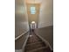A long stairwell featuring neutral walls, carpeted stairs, and a chandelier above the entrance at 403 Buckboard Ln, Locust Grove, GA 30248