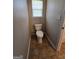 Neutral toned bathroom features a commode and a window for natural lighting at 403 Buckboard Ln, Locust Grove, GA 30248
