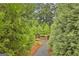 Secluded backyard pathway leading to a cozy fire pit, surrounded by lush trees at 3028 Pruitt Ln, Smyrna, GA 30080