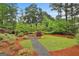 Beautifully landscaped backyard featuring a charming stone fire pit area and lush greenery at 3028 Pruitt Ln, Smyrna, GA 30080